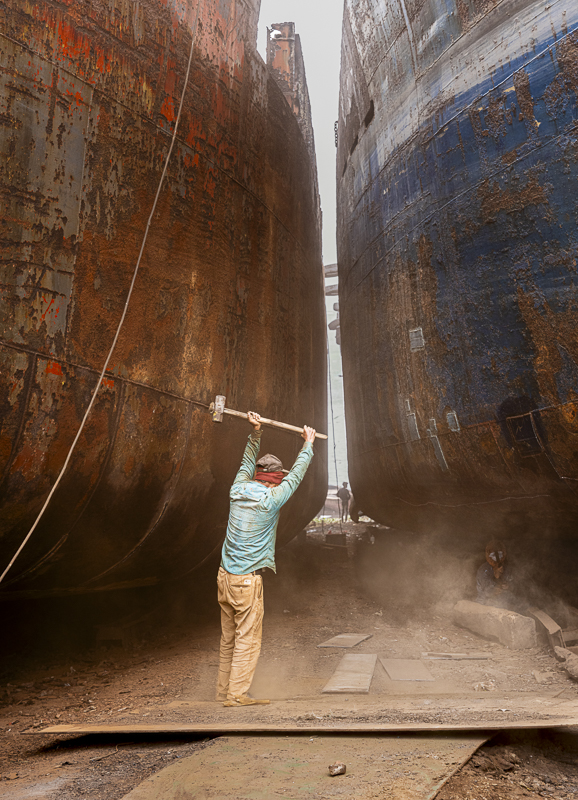 Man with tool raised over his head in Bangladesh